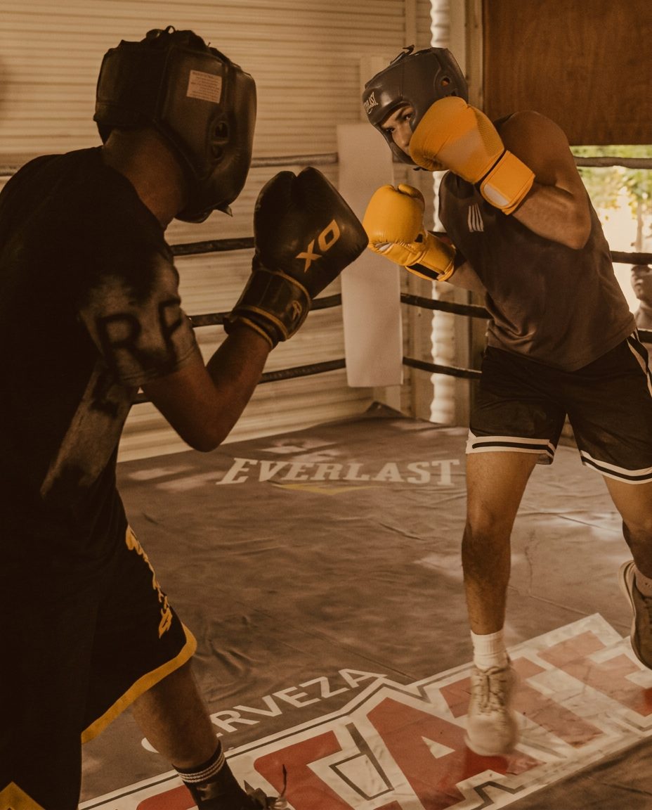 Two fighters sparring in the ring at golden hour